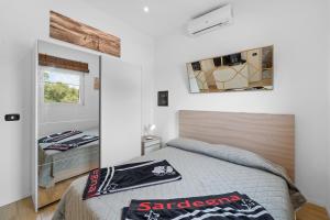a bedroom with a bed and a mirror on the wall at Villa Matteo Suite in Porto Columbu - Perdʼe Sali +17 photos