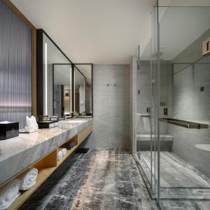 a bathroom with two sinks and a shower at Merlinhod Hotel Hejin Fengyuan in Hejin +17 photos