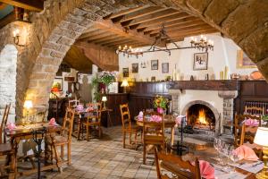 a dining room with tables and a fireplace at Le Vieux Logis in Yvoire