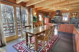 a large kitchen with a wooden table and chairs at Grange de Fonville - Evolène - Valais in Evolène