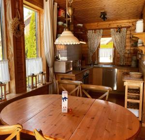 a kitchen with a wooden table in a cabin at Wild West Lodge 48 Western-Feeling im Harz in Hasselfelde