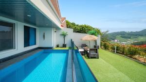a swimming pool in the backyard of a house at Namhae Eagless Poolvilla Pension in Namhae
