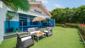 a patio with chairs and an umbrella and a table at Namhae Eagless Poolvilla Pension in Namhae