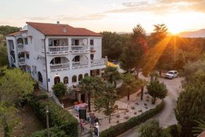 a large white house with a balcony on a street at Restaurant & Rooms Nino in Porat