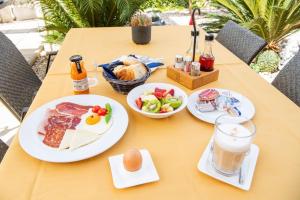 a table with plates of food and a drink at Restaurant & Rooms Nino in Porat