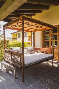 a bed under a wooden canopy on a patio at Casa rural en plena naturaleza, playa, senderismo in Villahormes