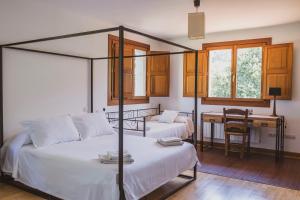 a bedroom with two beds and a desk in it at Casa rural en plena naturaleza, playa, senderismo in Villahormes