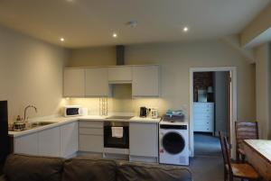 een keuken met witte kasten en een bank in een kamer bij Unique, City-Center Location in Salisbury