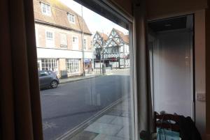 een raam met uitzicht op een straat met gebouwen bij Unique, City-Center Location in Salisbury