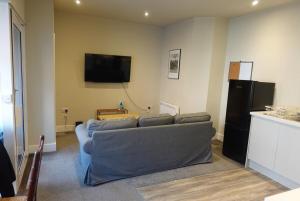 een woonkamer met een bank en een flatscreen-tv bij Unique, City-Center Location in Salisbury