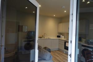 een keuken met witte kasten en een aanrechtblad bij Unique, City-Center Location in Salisbury +2 foto's