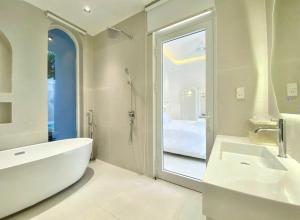 Un baño con bañera, lavabo y espejo. en Villa Đà nẵng Lavender Luxury, en Da Nang