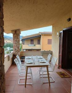 a table and white chairs on a patio at Casa vacanza tra il mare e il centro di San Teodoro in San Teodoro