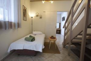 een kleine slaapkamer met een bed en een trap bij Sophia's Summer Residence in Tolo