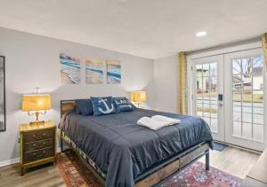 um quarto com uma cama com lençóis azuis e uma janela em Walk to Parks! Dining & Lake! Close to Hike Trails! em Watkins Glen