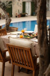 Una mesa con un plato de comida junto a una piscina. en La Grenadine Hotel, en Alacati