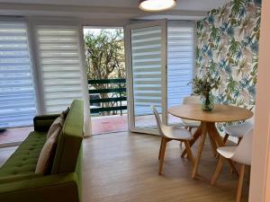 ein Wohnzimmer mit einer grünen Couch und einem Tisch in der Unterkunft Sunset Grao Beach in Grao de Castellón