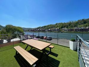 a picnic table on a balcony with a view of a river at Duplex des souverains in Dinant
