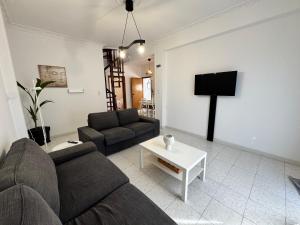 a living room with a couch and a tv at Evelyn House in Samos +29 photos