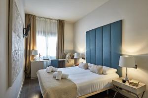 a bedroom with a large bed with a blue headboard at BBarcelona Rogent Flats in Barcelona