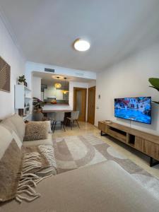 Una sala de estar con un sofá y un televisor de pantalla plana. en Изумительные апартаменты, en Calpe