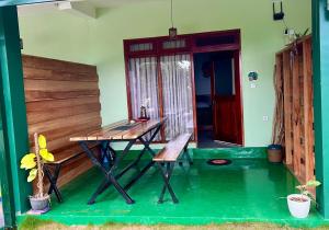 a patio with a table and a bench in a house at GAIA ELLA Ecolodge and Yoga Centre in Ella