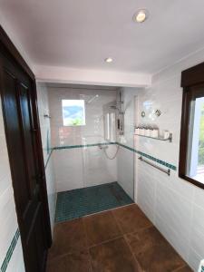 a bathroom with a shower with a glass door at Künstlerhaus Finca Madreselva mit atemberaubenden Weitblick mit Infinitypool, kleinen Teichen und vielen Sitzplätzen in Tolox Malaga im Nationalpark Sierra de las Nieves, ideal für Entspannung, aber auch zum Wandern in Tolox