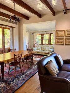 Una sala de estar con una mesa de madera y un sofá. en Sevilo Farmhouse, en Stellenbosch