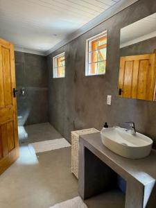 Un baño con lavabo blanco y ducha en Sevilo Farmhouse, en Stellenbosch 35 fotos más