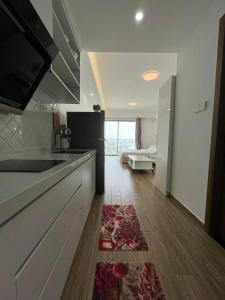 a kitchen with a black refrigerator and a living room at Condo Hotel apartment for rent in Phnom Penh City in Phnom Penh