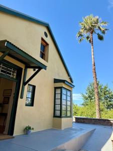 una casa con una palmera delante en Sevilo Farmhouse, en Stellenbosch