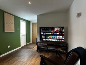 a living room with a large flat screen tv at Entire Apartment super king bed close to Town Centre in Colchester