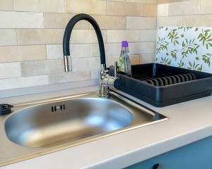 a stainless steel sink in a kitchen with a black sink at NextSpace Nr 20 in Sfântu-Gheorghe