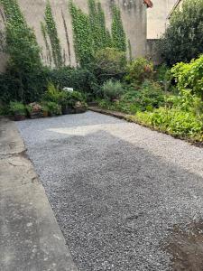 a walkway in a garden with plants and flowers at L'appart de la Rivière in Moulins