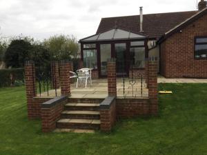 a screened in porch with a table and a patio at Applewood in South Wheatley