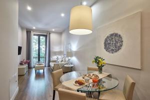 a dining room and living room with a glass table at BBarcelona Rogent Flats in Barcelona