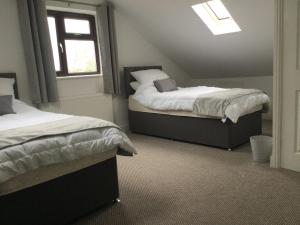 a bedroom with two beds and a window at Applewood in South Wheatley