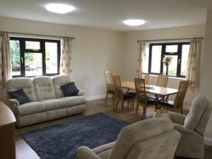 a living room with a couch and a table and chairs at Applewood in South Wheatley