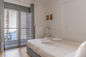 Un dormitorio con una cama y una ventana grande en Elvita Apartments, en Atenas