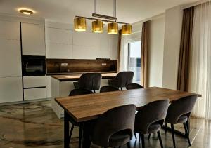 a kitchen with a wooden table and chairs at Vila OASIS - Zadar, Vrsi in Vrsi