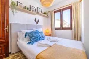 une chambre avec un lit blanc avec des oreillers bleus dans l'établissement Porto Cristo 6 persons, à Manacor