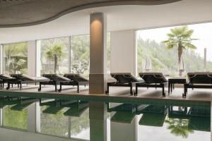 a pool with chairs and a table and water at Hotel Kiendl in Schenna +36 photos