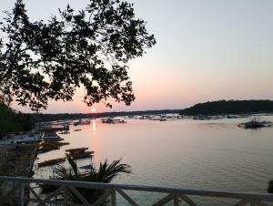 a sunset over a river with boats in it at Aiko Beach Isla Sunrise Resort in Bolinao
