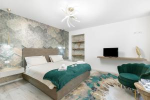 Un dormitorio con una cama y una silla verde. en Casa Elda - Happy Rentals, en Arco