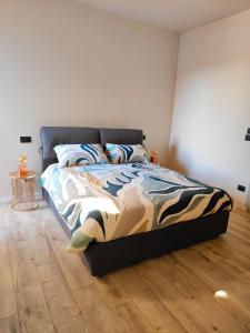 a bedroom with a bed and a wooden floor at La Morra Apartments in La Morra
