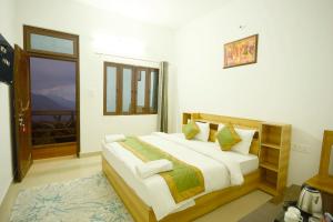 Postel nebo postele na pokoji v ubytování LA Riqueza Sushanti Retreat - Mountain View Rooms with Balcony # Pure Veg Restaurant # Jain Food Available # Parking # Customer's choice Hotel