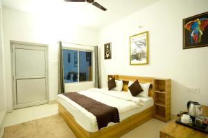 Postel nebo postele na pokoji v ubytování LA Riqueza Sushanti Retreat - Mountain View Rooms with Balcony # Pure Veg Restaurant # Jain Food Available # Parking # Customer's choice Hotel