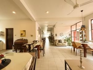 a living room with tables and chairs and a couch at Maria Villa by Blue Bird in Negombo