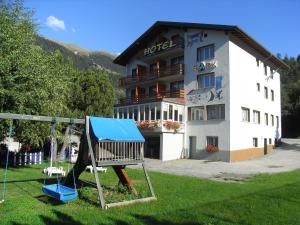 a hotel with a playground in front of a building at Hotel Park in Fiesch