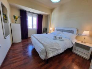 un grande letto bianco in una camera da letto con pavimento in legno di Turística Cervantes a Priego de Córdoba